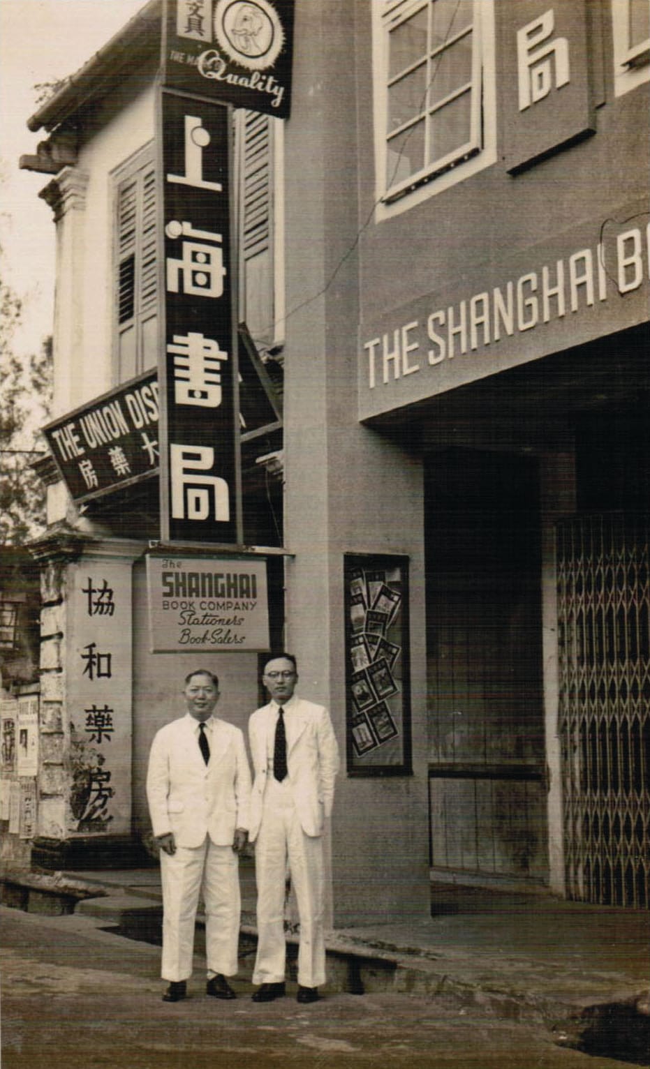 摄于1951年，新加坡上海书局创办人陈岳书（左）和王叔旸先生在 书店前留影。（蒙上海书局提供）